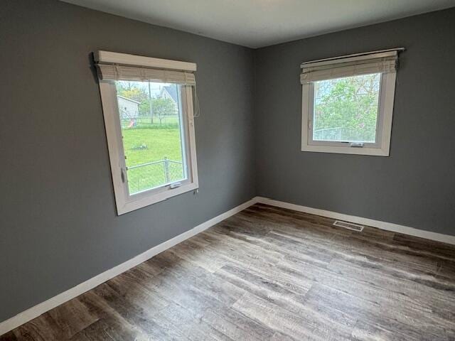 418 N Hemlock St, Evart, MI 49631 - empty room featuring plenty of natural light, wood finished floors, and baseboards