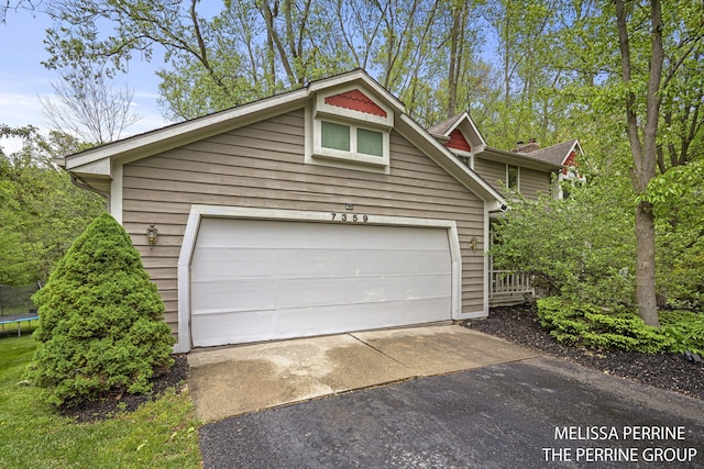 7359 Cascade Woods Dr SE, Grand Rapids, MI 49546 - garage featuring a trampoline and driveway