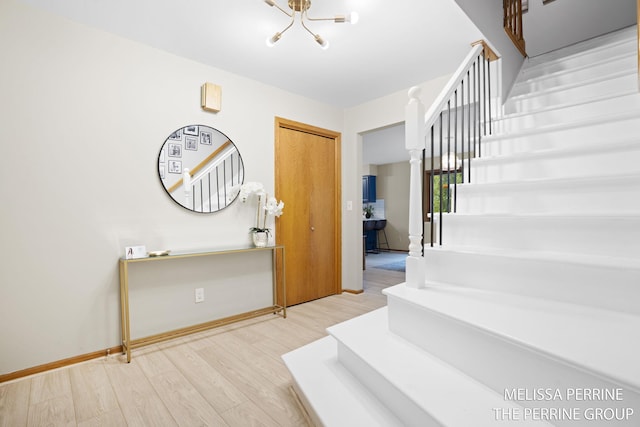 7359 Cascade Woods Dr SE, Grand Rapids, MI 49546 - stairway with a chandelier, wood finished floors, and baseboards