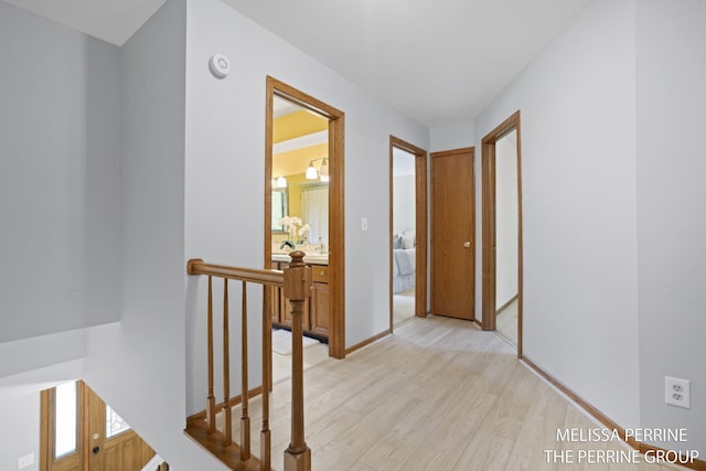 7359 Cascade Woods Dr SE, Grand Rapids, MI 49546 - hallway with an upstairs landing, light wood-style floors, and baseboards