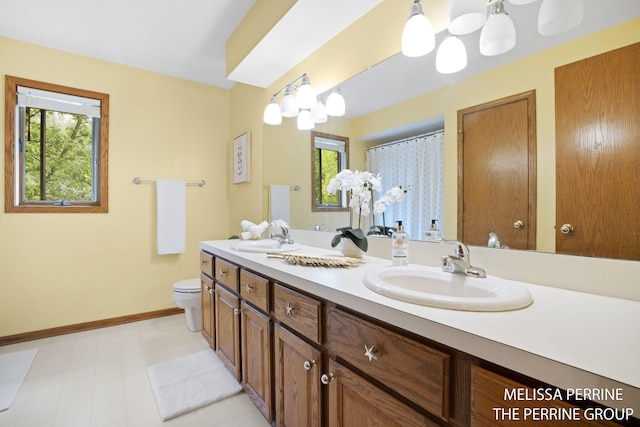 7359 Cascade Woods Dr SE, Grand Rapids, MI 49546 - bathroom featuring toilet, double vanity, tile patterned floors, and baseboards