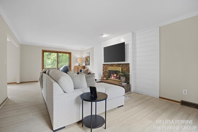 7359 Cascade Woods Dr SE, Grand Rapids, MI 49546 - living room featuring light wood finished floors, a fireplace, baseboards, and ornamental molding
