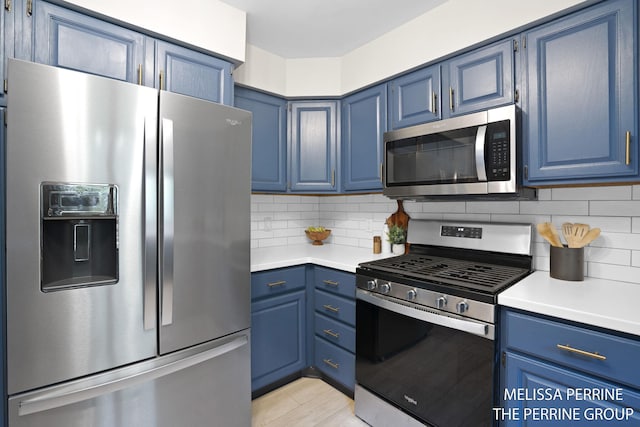 7359 Cascade Woods Dr SE, Grand Rapids, MI 49546 - kitchen featuring appliances with stainless steel finishes, blue cabinetry, light countertops, and backsplash
