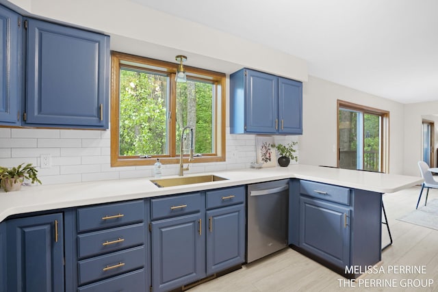 7359 Cascade Woods Dr SE, Grand Rapids, MI 49546 - kitchen featuring dishwasher, a sink, blue cabinetry, and a peninsula