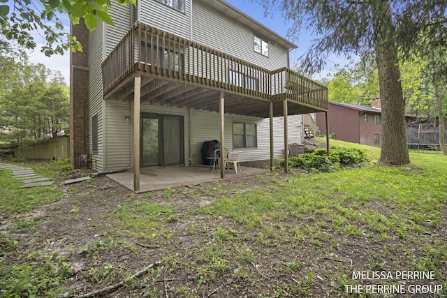 7359 Cascade Woods Dr SE, Grand Rapids, MI 49546 - rear view of house with a patio, a deck, a trampoline, and a lawn