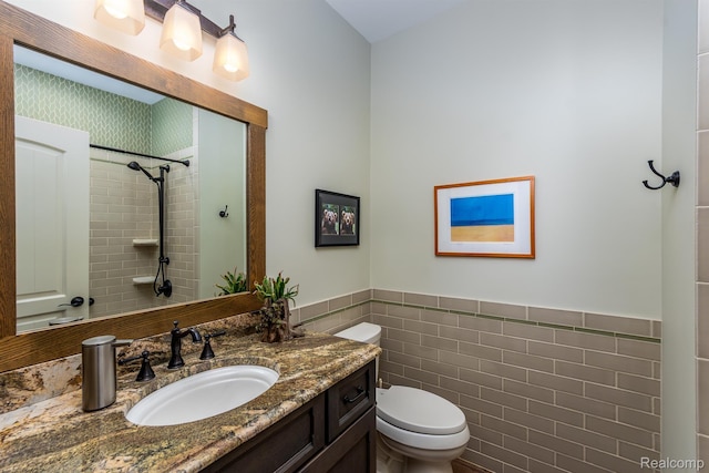 5502 E Alyssa Ct, White Lake, MI 48383 - bathroom featuring tile walls, vanity, toilet, tiled shower, and a wainscoted wall