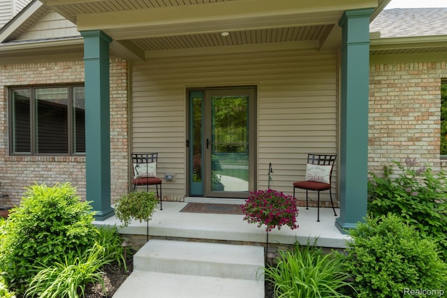 5502 E Alyssa Ct, White Lake, MI 48383 - property entrance featuring a porch and brick siding