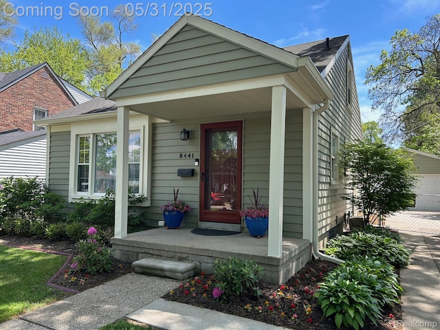 8441 Colgate St, Oak Park, MI 48237 - entrance to property featuring a porch, a garage, and roof with shingles
