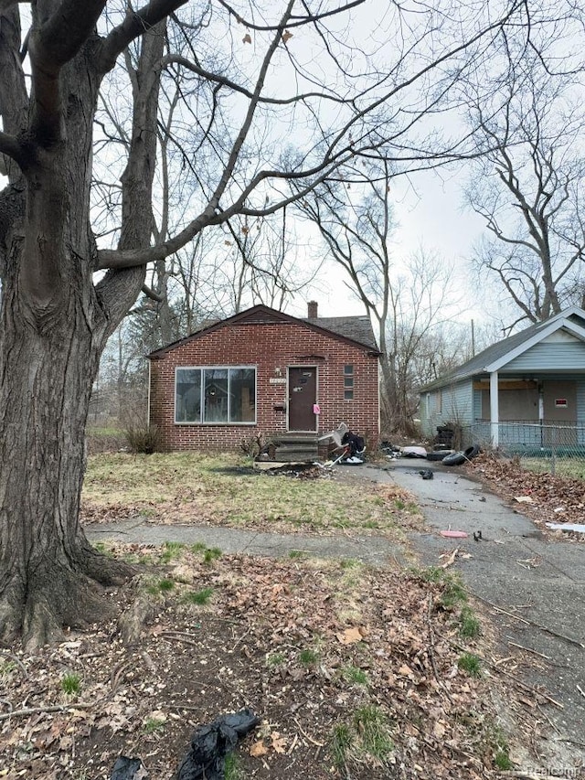 14632 Dolphin St, Detroit, MI 48223 - view of front facade featuring brick siding, a chimney, and driveway