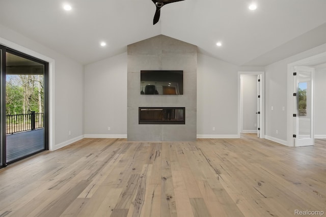4030 Metamora Rdg, Metamora, MI 48455 - unfurnished living room with a ceiling fan, vaulted ceiling, light wood finished floors, a tile fireplace, and baseboards
