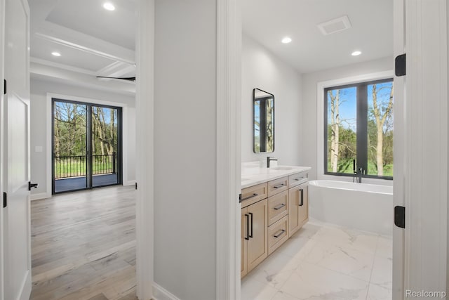 4030 Metamora Rdg, Metamora, MI 48455 - full bathroom with double vanity, a freestanding tub, plenty of natural light, recessed lighting, and baseboards