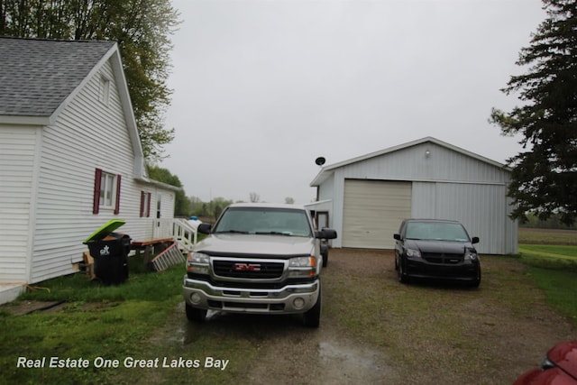 4141 Sagatoo Rd, Standish, MI 48658 - view of property exterior with roof with shingles, a garage, an outbuilding, and dirt driveway