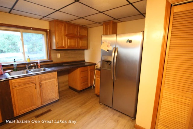 4141 Sagatoo Rd, Standish, MI 48658 - kitchen with stainless steel refrigerator with ice dispenser, a sink, light wood-style floors, a paneled ceiling, and dark countertops