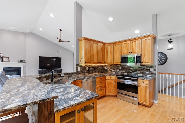 3079 Windmill Ct, Adrian, MI 49221 - kitchen with stainless steel appliances, lofted ceiling, light wood-style flooring, open floor plan, and decorative backsplash