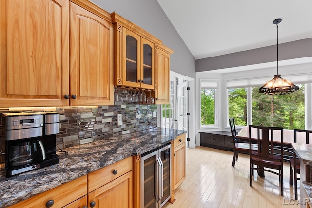 3079 Windmill Ct, Adrian, MI 49221 - kitchen with wine cooler, vaulted ceiling, backsplash, glass insert cabinets, and light wood-style floors