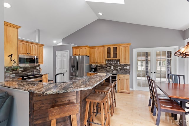 3079 Windmill Ct, Adrian, MI 49221 - kitchen featuring appliances with stainless steel finishes, a peninsula, french doors, decorative backsplash, and glass insert cabinets