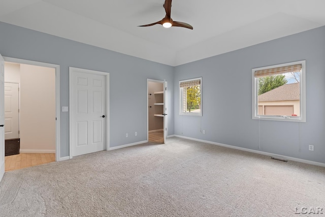 3079 Windmill Ct, Adrian, MI 49221 - unfurnished bedroom with carpet, baseboards, a walk in closet, and ceiling fan