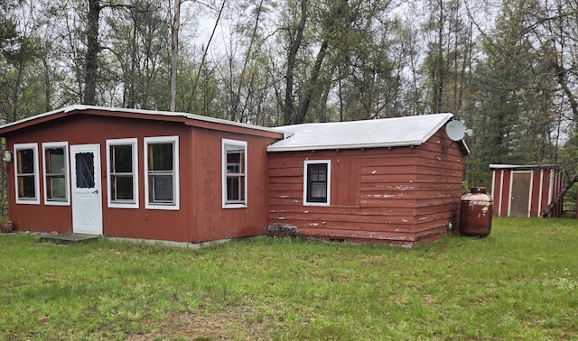 5282 N May Rd, Luther, MI 49656 - view of side of home with a lawn and an outbuilding