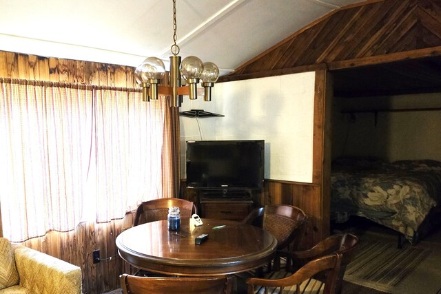 5282 N May Rd, Luther, MI 49656 - dining area featuring a chandelier, wooden walls, and lofted ceiling