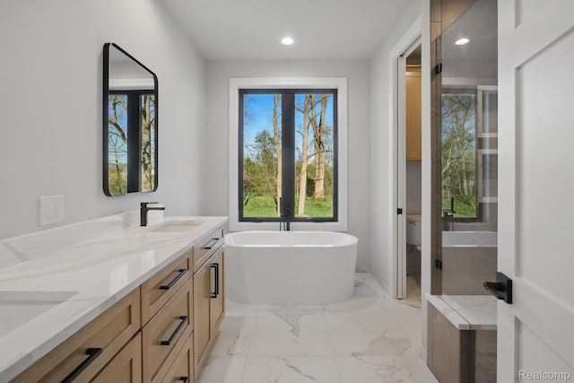 4075 Metamora Rdg, Metamora, MI 48455 - full bath featuring double vanity, marble finish flooring, a freestanding tub, recessed lighting, and toilet