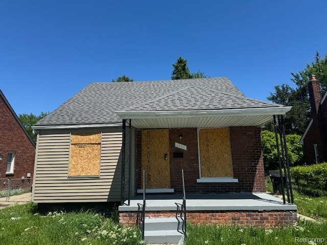 6106 Cadieux Rd, Detroit, MI 48224 - bungalow featuring roof with shingles, covered porch, and brick siding