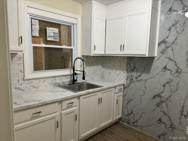 6106 Cadieux Rd, Detroit, MI 48224 - kitchen featuring a sink, white cabinetry, light stone counters, dark wood finished floors, and backsplash