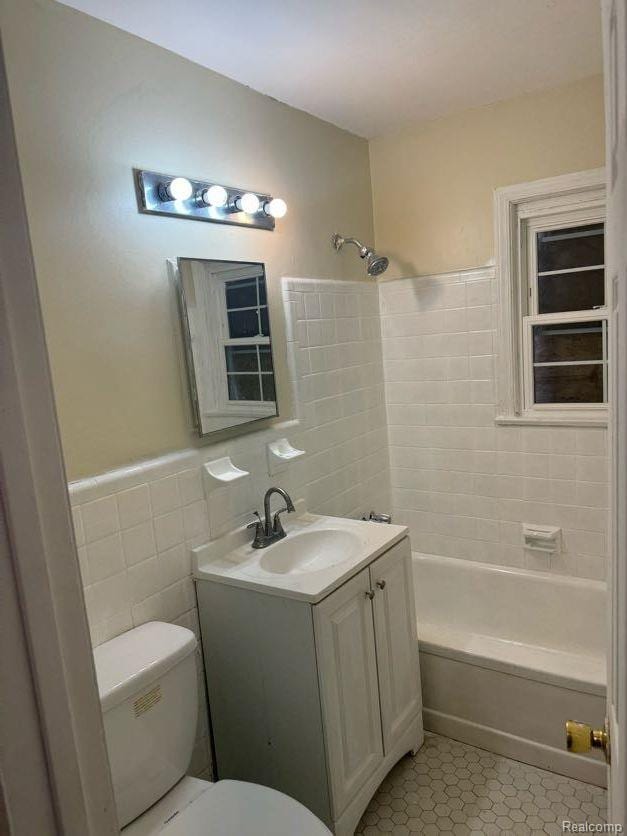 6106 Cadieux Rd, Detroit, MI 48224 - full bathroom featuring vanity, toilet, tile patterned floors, bathing tub / shower combination, and tile walls