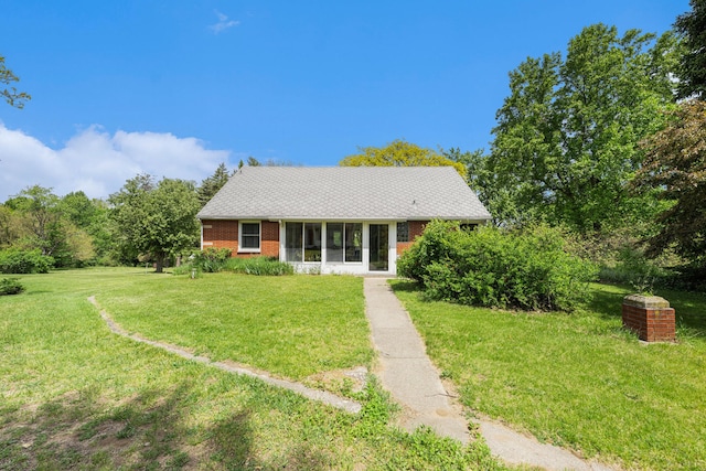10827 N 12th St, Plainwell, MI 49080 - view of front of property with a sunroom, brick siding, and a front yard