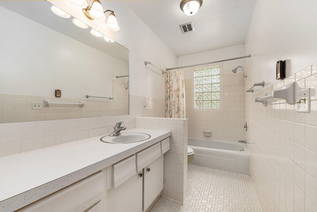 10827 N 12th St, Plainwell, MI 49080 - full bathroom featuring tile walls, toilet, shower / bathtub combination with curtain, tile patterned floors, and vanity