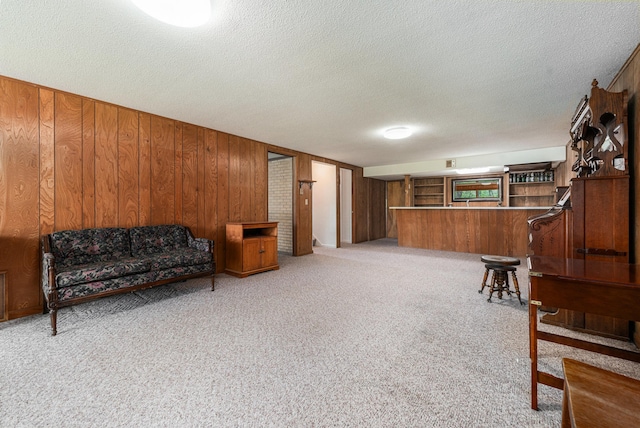 10827 N 12th St, Plainwell, MI 49080 - living area with a textured ceiling, wood walls, carpet, and a dry bar