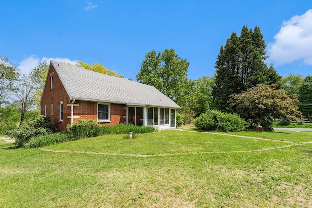 10827 N 12th St, Plainwell, MI 49080 - view of front facade featuring a sunroom, a front lawn, and brick siding