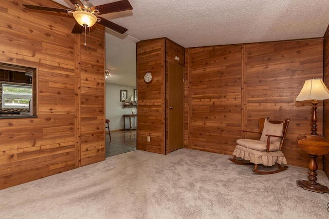 10303 Walnut Dr, Three Rivers, MI 49093 - living area featuring wooden walls, carpet, a ceiling fan, and a textured ceiling