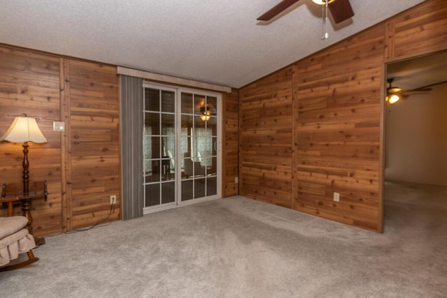 10303 Walnut Dr, Three Rivers, MI 49093 - empty room with ceiling fan, wood walls, vaulted ceiling, a textured ceiling, and carpet flooring