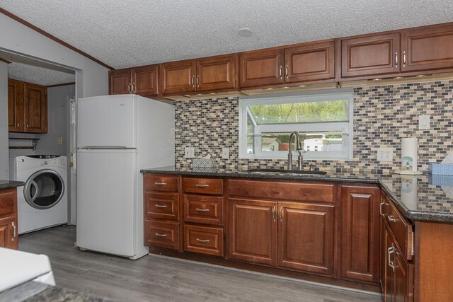 10303 Walnut Dr, Three Rivers, MI 49093 - kitchen featuring washer / dryer, freestanding refrigerator, a sink, wood finished floors, and tasteful backsplash