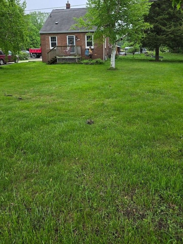 20375 Sumpter Rd, Belleville, MI 48111 - view of green lawn with a deck