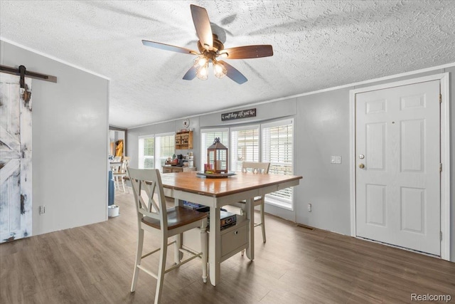 351 N Squirrel Rd, Auburn Hills, MI 48326 - dining room featuring a textured ceiling, wood finished floors, ceiling fan, and a barn door