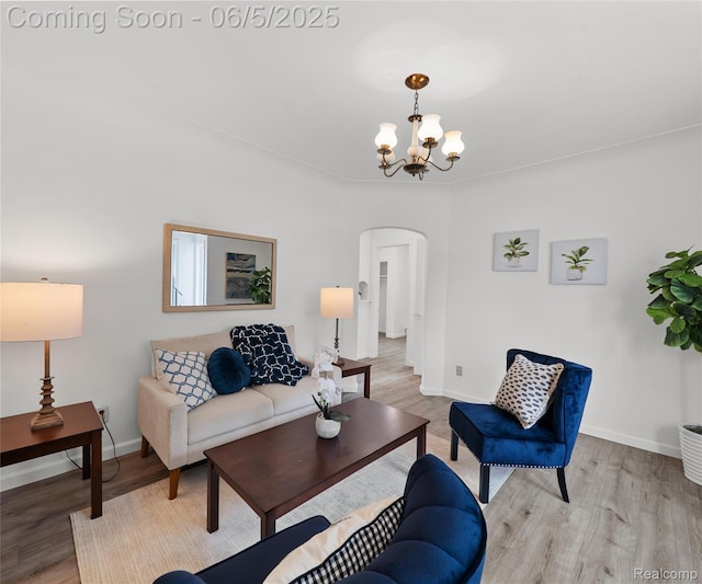 31777 Hennepin St, Garden City, MI 48135 - living area featuring arched walkways, a chandelier, light wood finished floors, and baseboards