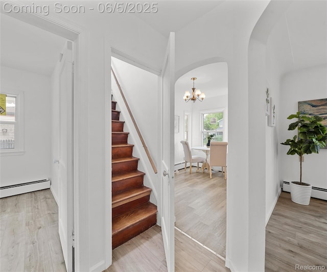 31777 Hennepin St, Garden City, MI 48135 - stairway with arched walkways, baseboard heating, wood finished floors, and a chandelier