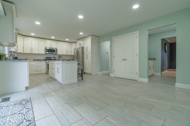 14607 Stratford, Shelby Twp, MI 48315 - kitchen featuring stainless steel appliances, white cabinetry, a kitchen bar, recessed lighting, and a center island