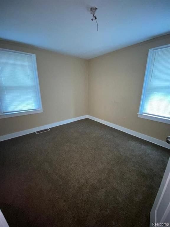 9966 Hartwell St, Detroit, MI 48227 - unfurnished room with plenty of natural light, dark colored carpet, and baseboards