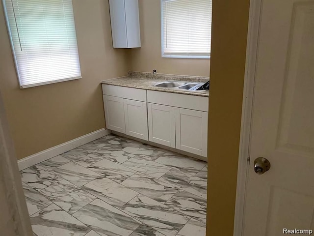 9966 Hartwell St, Detroit, MI 48227 - kitchen with light marble finish flooring, a sink, baseboards, light countertops, and white cabinets