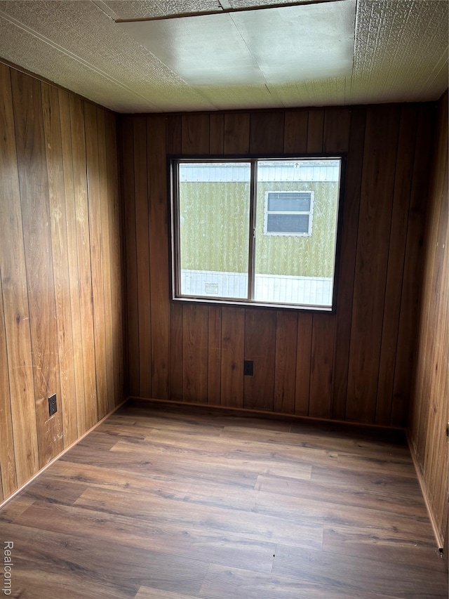 2455 Laura Dr, Flint, MI 48507 - spare room featuring wood finished floors and wood walls