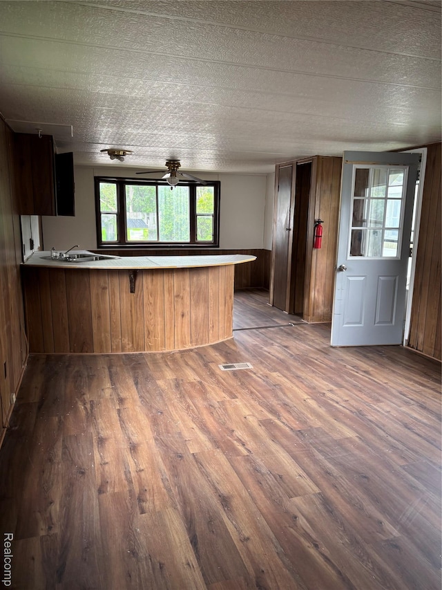 2455 Laura Dr, Flint, MI 48507 - kitchen with dark wood finished floors, a peninsula, plenty of natural light, and wood walls