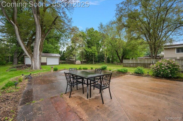 2920 Pinto Dr, Commerce Twp, MI 48382 - view of patio / terrace featuring an outdoor structure, outdoor dining area, a detached garage, and view of scattered trees