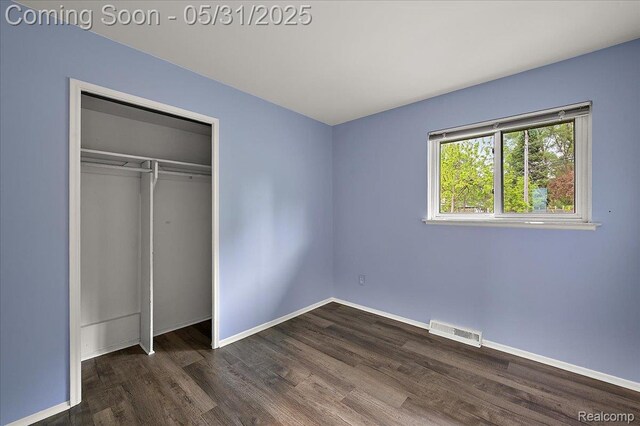 2920 Pinto Dr, Commerce Twp, MI 48382 - unfurnished bedroom with dark wood-style flooring, baseboards, and a closet