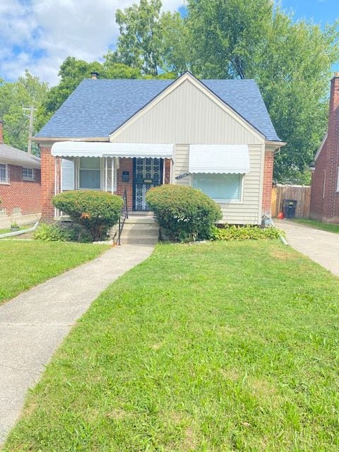 17706 Stahelin Ave, Detroit, MI 48219 - bungalow-style home featuring brick siding, a shingled roof, and a front lawn