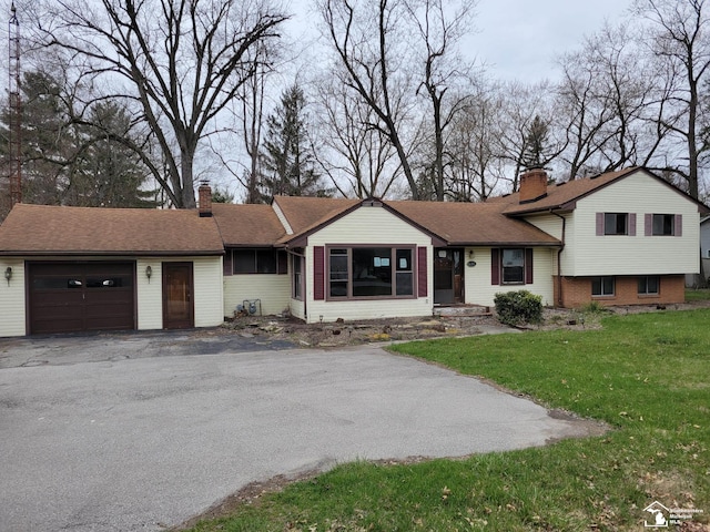 8255 Secor Rd, Lambertville, MI 48144 - tri-level home with a chimney, an attached garage, asphalt driveway, and a front lawn