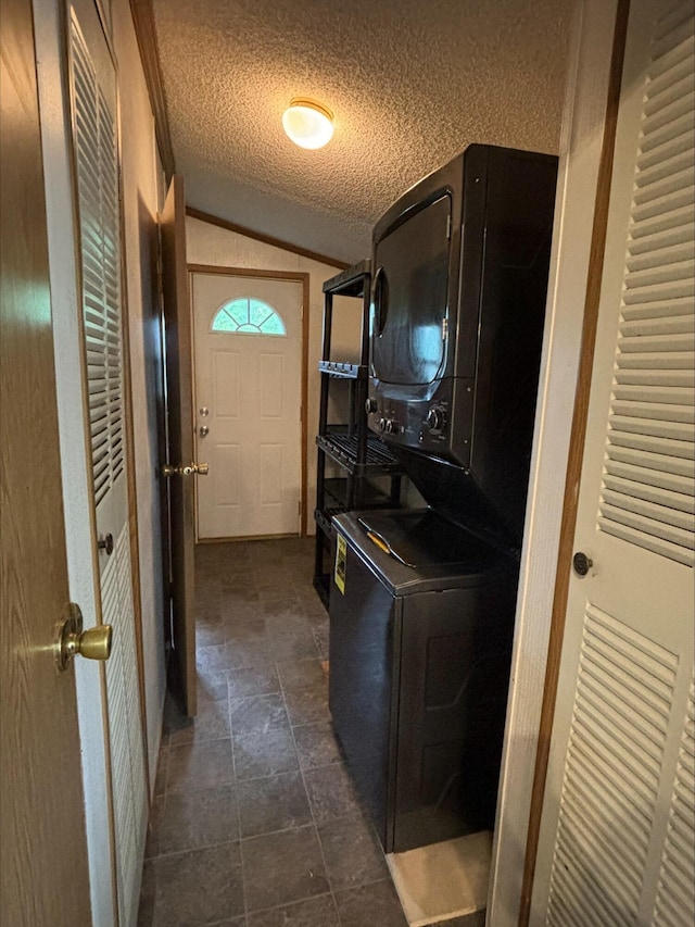 815 Hyatt St, Eaton Rapids, MI 48827 - laundry area with stacked washer / dryer, a textured ceiling, and dark stone finish flooring