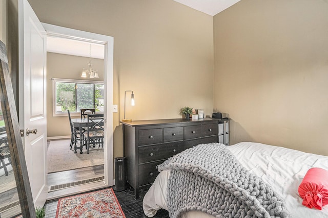 201 Page St NE, Grand Rapids, MI 49505 - bedroom featuring baseboards, a chandelier, and wood finished floors
