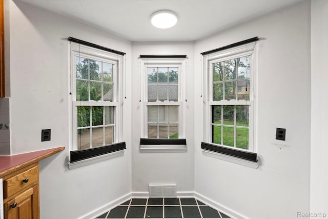 99 Wenonah Dr, Pontiac, MI 48341 - doorway with dark tile patterned flooring and baseboards